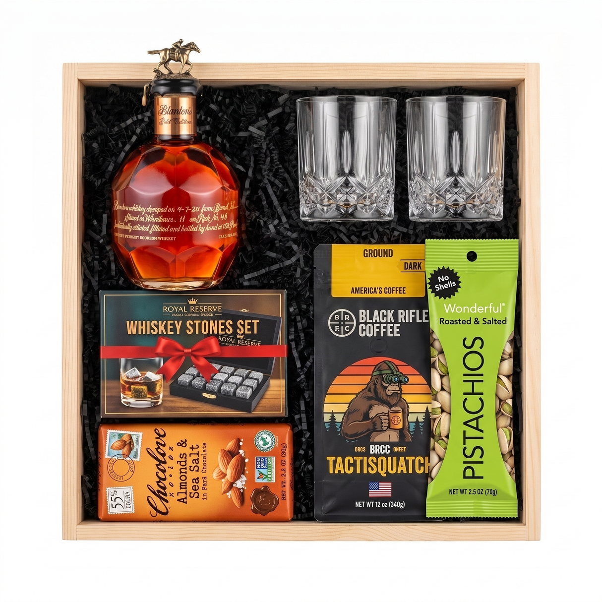 Blanton's Gold Edition bourbon gift crate with two crystal-cut glasses, whiskey stones, ground coffee, dark chocolate, and pistachios nested in a natural wood crate.