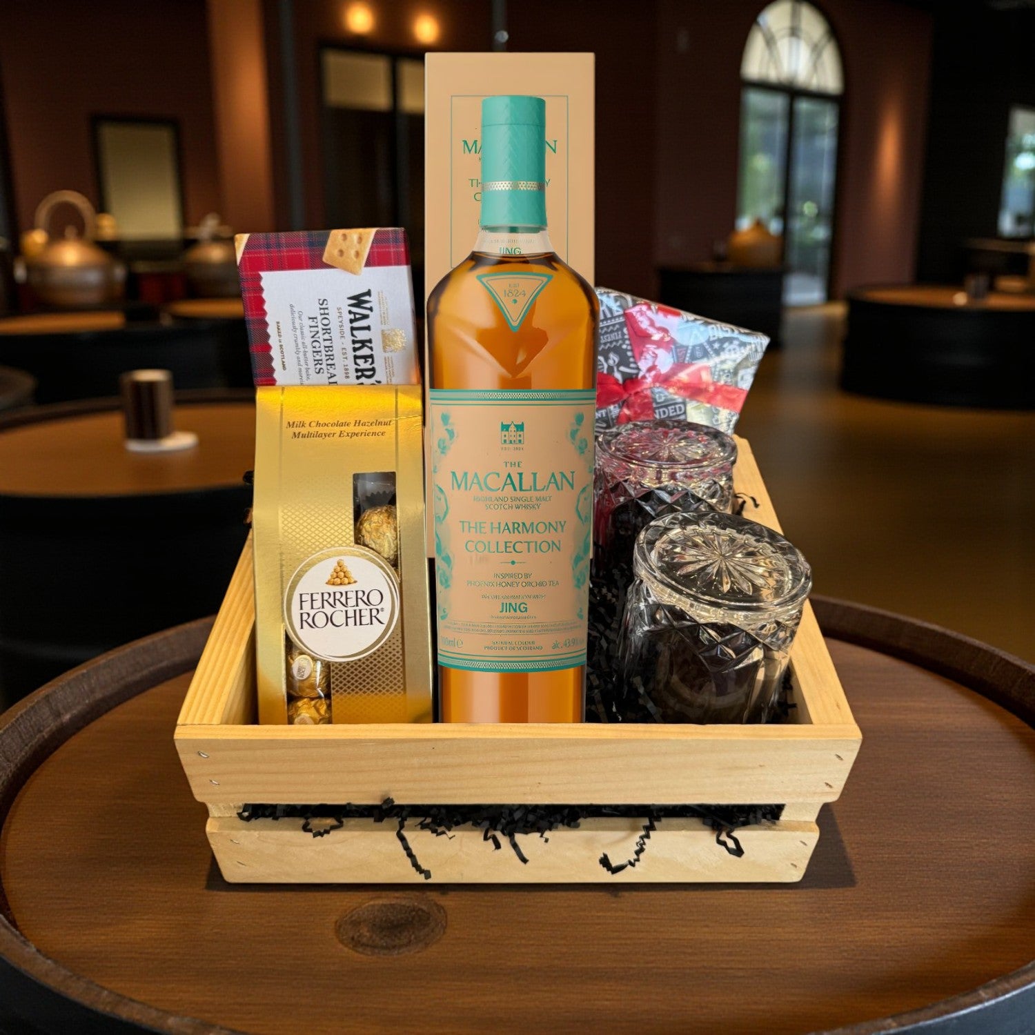 Macallan Harmony Phoenix Honey Orchid Tea Gift Crate featuring whisky, Ferrero Rocher, Walkers shortbread, and crystal-cut glasses arranged in a wooden crate – lifestyle photo for Top Bourbon