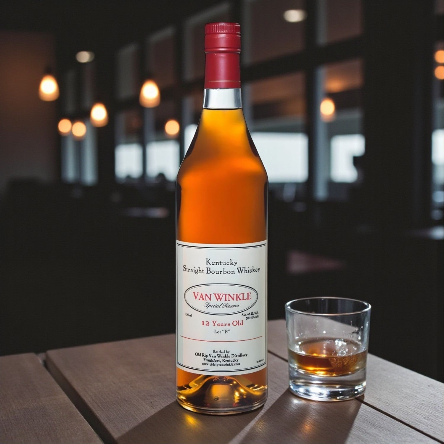 Engravable Pappy Van Winkle Special Reserve 12 Year Lot B Bourbon bottle on wooden table beside glass of bourbon under warm lighting – Top Bourbon lifestyle image