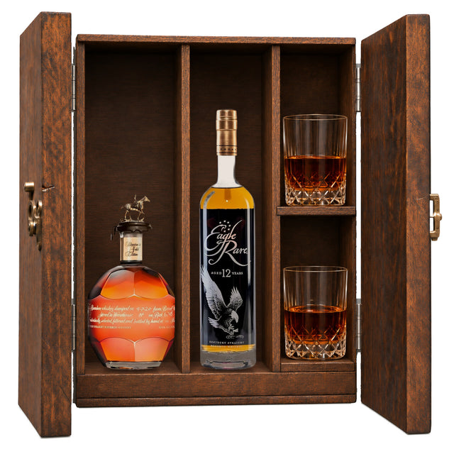 Blanton's Gold Edition & Eagle Rare 12 Year in a wooden gift box with two crystal glasses on white