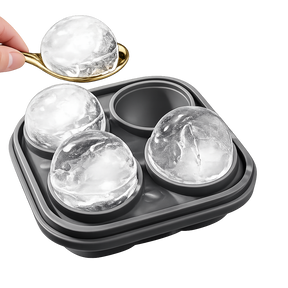 Whiskey ice mold tray with large ice spheres and spoon on white background