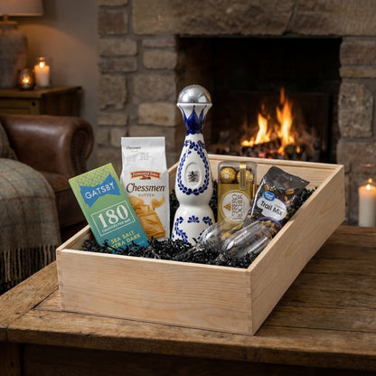 Clase Azul Reposado tequila gift set with tequila flutes, Ferrero Rocher chocolates, Gatsby dark chocolate, Chessmen cookies and trail mix arranged in wooden gift crate