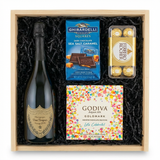 Dom Pérignon vintage Champagne 750ml gift crate with Ghirardelli Sea Salt Caramel Squares, Godiva Let's Celebrate chocolate box, and Ferrero Rocher hazelnut chocolates in natural wood crate with black crinkle fill