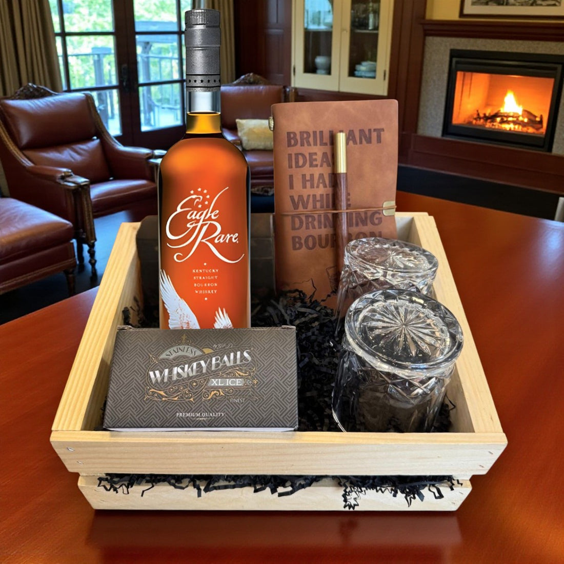 Engraved Eagle Rare 10 Year Bourbon Gift Crate with old-fashioned crystal-cut glasses, whiskey balls, and leather journal beside a fireplace – Top Bourbon lifestyle image