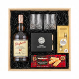 Glenfarclas 12 Year Sherry Cask Single Malt Scotch Whisky gift crate with crystal old fashioned glasses, whiskey stones, Ferrero Rocher chocolates, Walker's shortbread, and natural wood crate with black crinkle fill