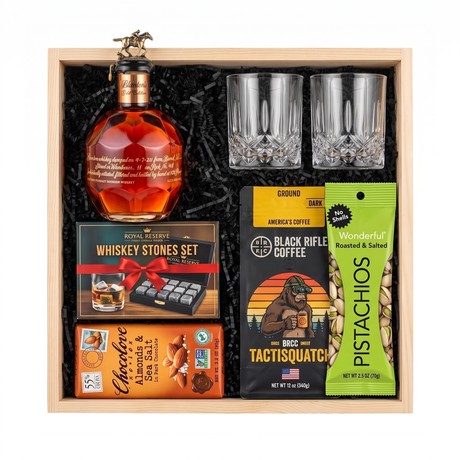 Blanton's Gold Edition bourbon gift crate with two crystal-cut glasses, whiskey stones, ground coffee, dark chocolate, and pistachios nested in a natural wood crate.