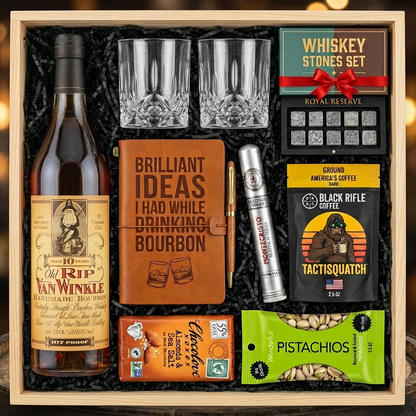 Old Rip Van Winkle 10 Year 107 Proof Top Shelf gift crate with bourbon journal, Montecristo Platinum cigar, Black Rifle Coffee, Chocolove chocolate, Wonderful Pistachios, crystal glasses, and Royal Reserve whiskey stones nestled in black zigzag crinkle paper inside wooden crate on rustic wood surface with warm ambient lighting