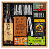 Old Rip Van Winkle 10 Year 107 Proof Top Shelf gift crate with tan vintage label and Rip Van Winkle character illustration, crystal-cut old fashioned glasses, Royal Reserve whiskey stones set with tray, faux-leather bourbon journal and pen set, Montecristo Platinum cigar tube, Black Rifle Coffee Tactisquatch blend, Chocolove Almonds & Sea Salt dark chocolate bar, and Wonderful Pistachios all nestled in black zigzag crinkle paper inside wooden crate on white background
