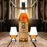 Engravable Old Rip Van Winkle 10 Year Bourbon Gift Set with two Glencairn glasses on rustic wooden table with bourbon barrels – Top Bourbon lifestyle image