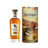 Wild Turkey Austin Nichols Archives Gold Foil Edition 16 Year bourbon 750ml bottle beside its autumn-scene limited-edition tube.