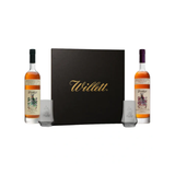 Black Willett gift box flanked by Willett Family Estate rye and bourbon 750ml bottles and two etched Willett glasses.
